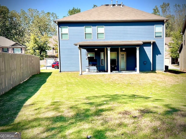 back of property with a patio area and a yard