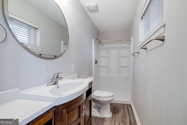 bathroom with a wealth of natural light, a shower, a textured ceiling, and hardwood / wood-style flooring