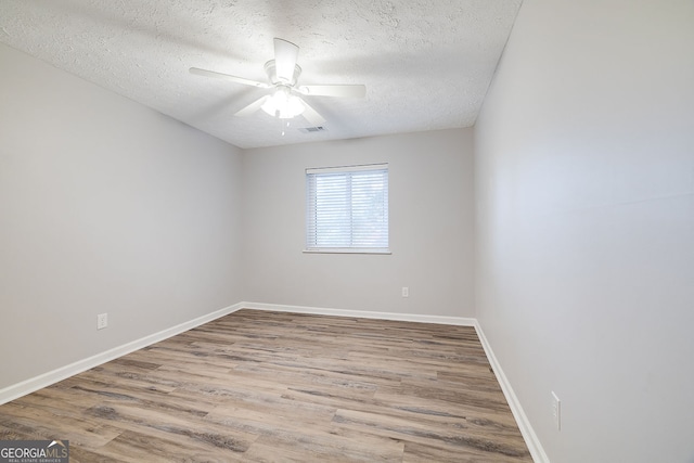 empty room featuring ceiling fan, hardwood / wood-style floors, and a textured ceiling