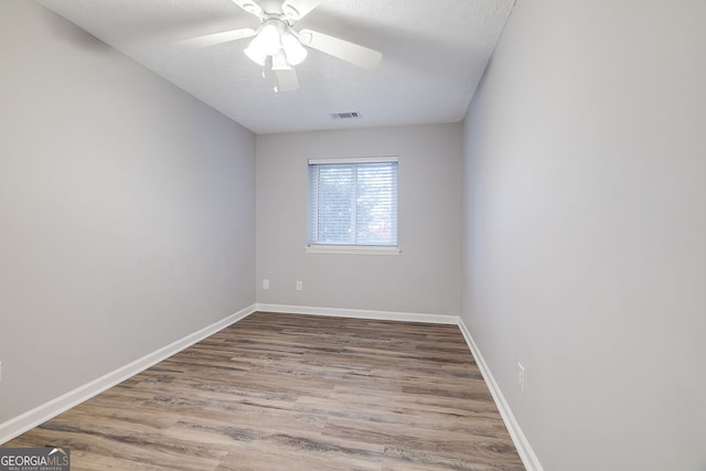 empty room featuring hardwood / wood-style floors, ceiling fan, and a textured ceiling