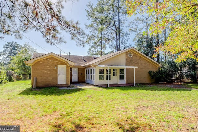 back of property featuring a lawn and a patio area