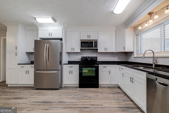 kitchen with sink, white cabinetry, stainless steel appliances, and light wood-type flooring