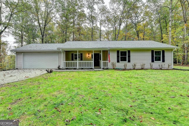 single story home featuring a front yard, a porch, and a garage