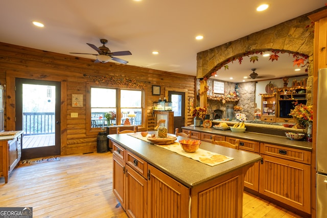 kitchen featuring ceiling fan, a center island, light wood-type flooring, and stainless steel refrigerator