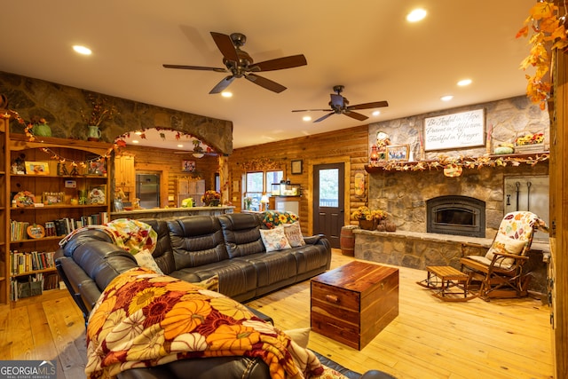 living room with ceiling fan, a fireplace, and light hardwood / wood-style floors