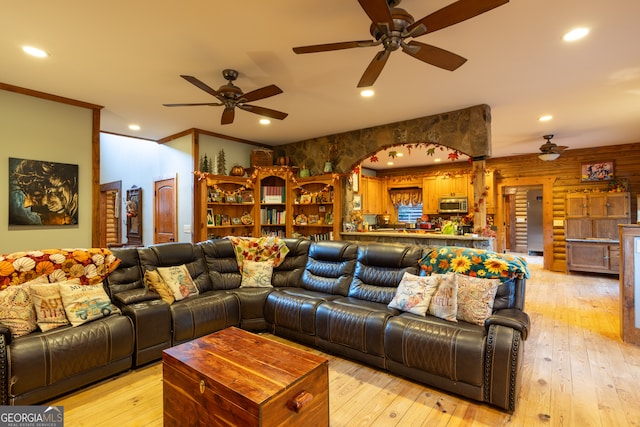 living room with light hardwood / wood-style flooring, ceiling fan, and crown molding