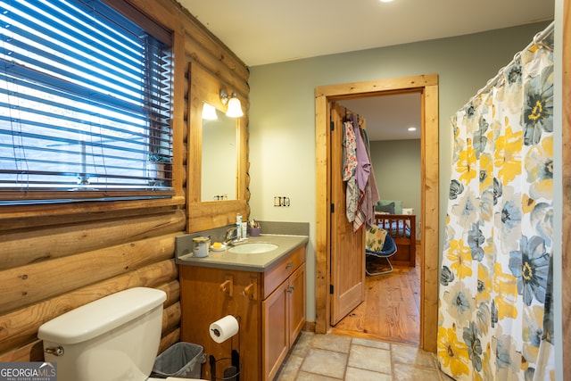 bathroom with vanity, a shower with shower curtain, toilet, rustic walls, and wood-type flooring