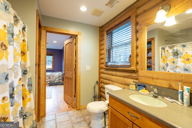 bathroom with vanity, toilet, wood-type flooring, and a wealth of natural light