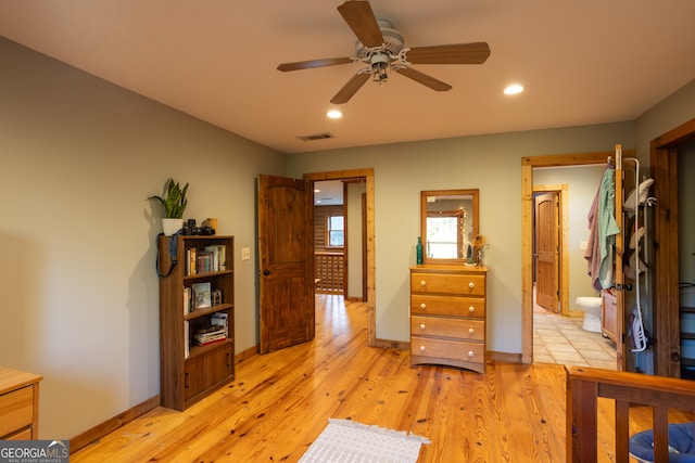 bedroom with connected bathroom, ceiling fan, and light wood-type flooring