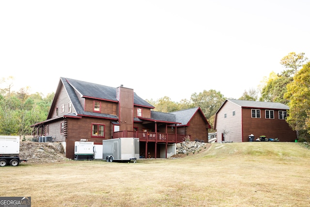 rear view of property featuring central AC, a lawn, and a wooden deck