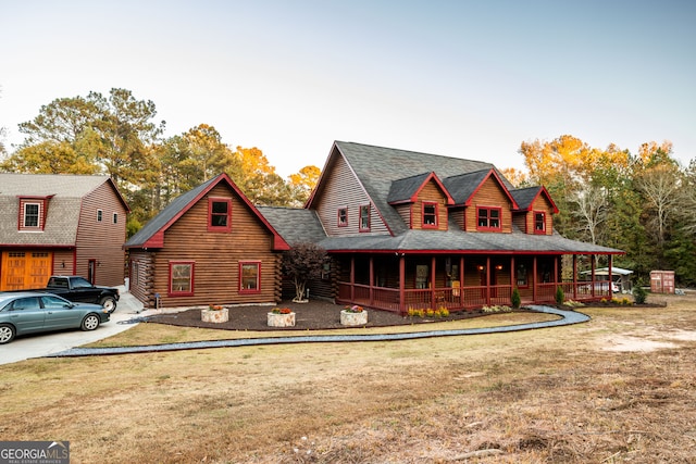 cabin with covered porch and a front yard