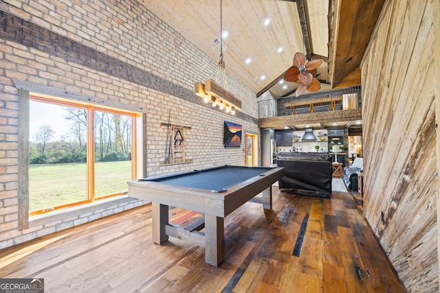 playroom featuring dark hardwood / wood-style flooring, high vaulted ceiling, brick wall, and pool table