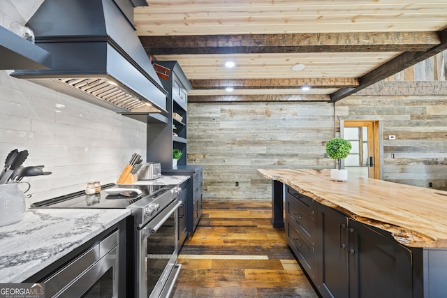 kitchen with butcher block counters, wooden walls, dark hardwood / wood-style floors, and appliances with stainless steel finishes