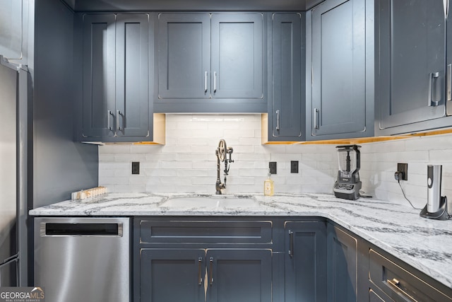 kitchen featuring tasteful backsplash, light stone counters, dishwasher, and sink