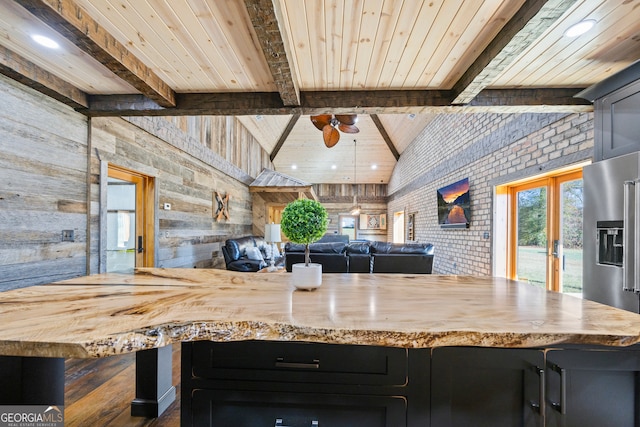 kitchen with vaulted ceiling with beams, wood ceiling, wooden walls, and french doors