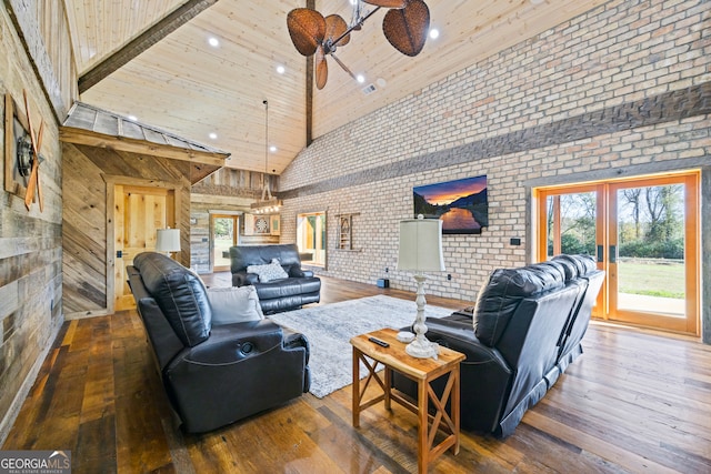 living room featuring hardwood / wood-style floors, ceiling fan, brick wall, and high vaulted ceiling