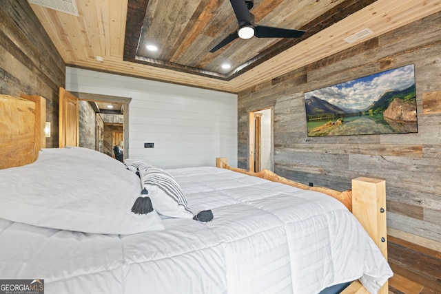 bedroom with wood ceiling, a tray ceiling, ceiling fan, wooden walls, and hardwood / wood-style flooring