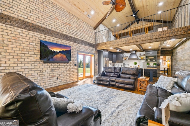 living room featuring high vaulted ceiling, hardwood / wood-style flooring, ceiling fan, wood ceiling, and brick wall