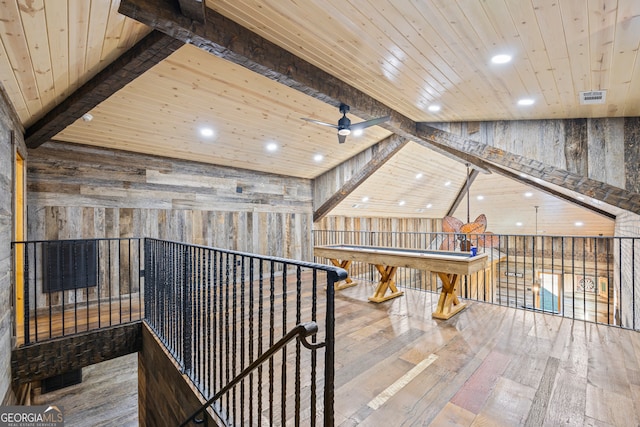 rec room featuring ceiling fan, wooden walls, wooden ceiling, hardwood / wood-style floors, and vaulted ceiling with beams