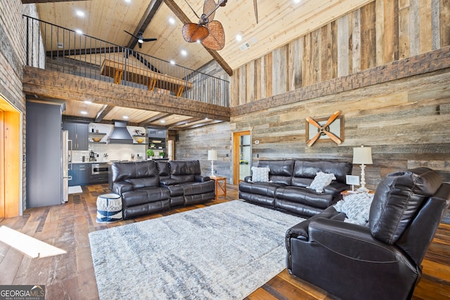 living room with ceiling fan, beamed ceiling, high vaulted ceiling, dark hardwood / wood-style floors, and wooden walls