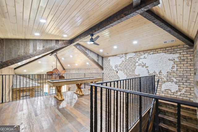 game room with wood walls, lofted ceiling with beams, hardwood / wood-style flooring, ceiling fan, and wood ceiling