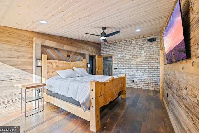 bedroom with dark hardwood / wood-style flooring, ceiling fan, wood walls, and brick wall