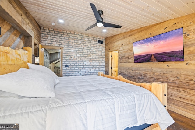 unfurnished bedroom featuring wood walls, hardwood / wood-style floors, ceiling fan, and brick wall