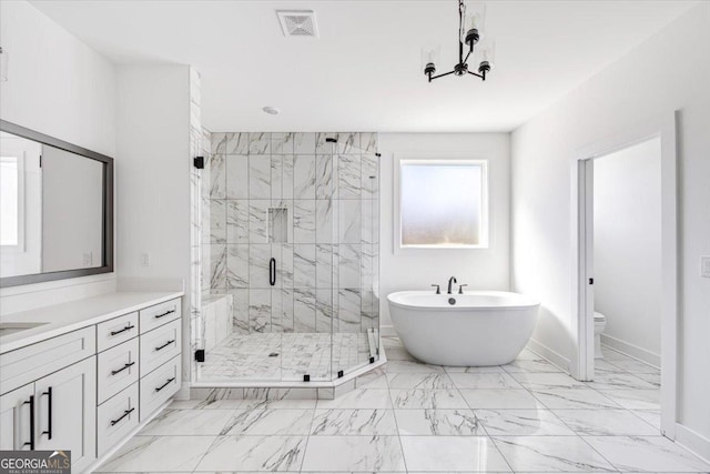 full bath with baseboards, toilet, marble finish floor, vanity, and a freestanding tub