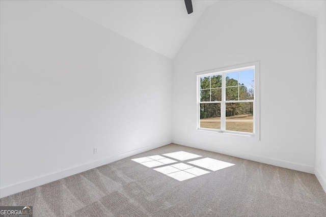 spare room featuring high vaulted ceiling, carpet flooring, and baseboards