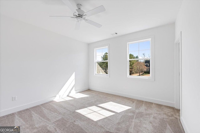 unfurnished room with baseboards, visible vents, and light colored carpet