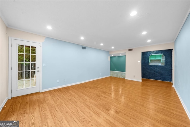 unfurnished living room with light wood-type flooring and crown molding