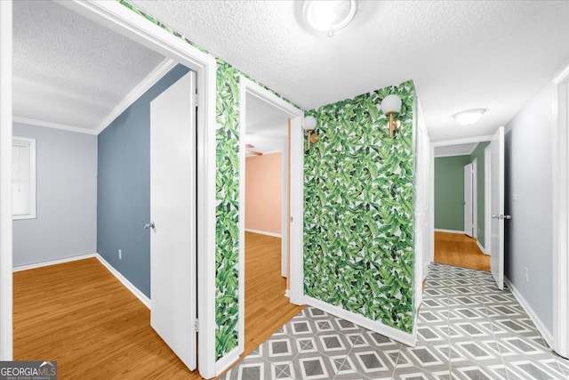 hallway with hardwood / wood-style flooring, crown molding, and a textured ceiling