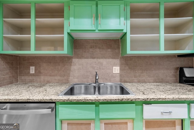 kitchen featuring dishwasher, sink, green cabinetry, tasteful backsplash, and light stone counters