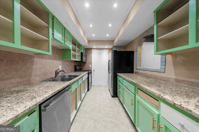 kitchen with light stone counters, sink, green cabinetry, and appliances with stainless steel finishes