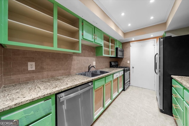 kitchen with light stone countertops, ornamental molding, stainless steel appliances, sink, and green cabinetry