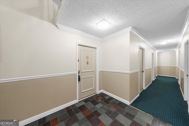 hallway with a textured ceiling and ornamental molding