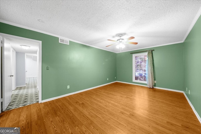 spare room with ceiling fan, wood-type flooring, a textured ceiling, and ornamental molding