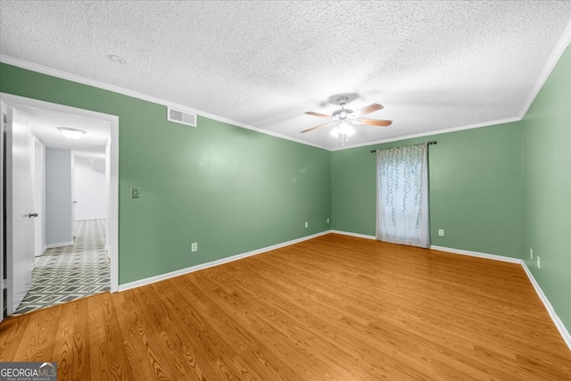 spare room with wood-type flooring, a textured ceiling, ceiling fan, and ornamental molding