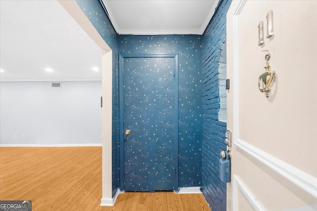 interior space featuring wood-type flooring and ornamental molding