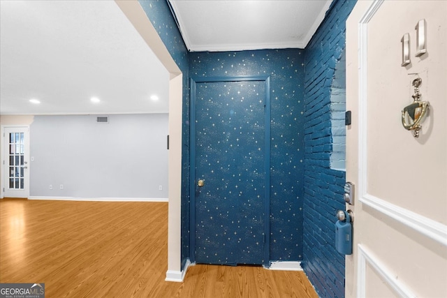 interior space with crown molding and light hardwood / wood-style flooring