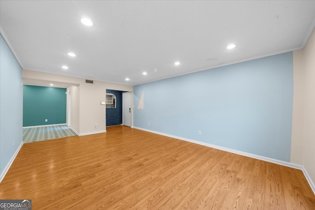 unfurnished living room featuring crown molding and light hardwood / wood-style floors