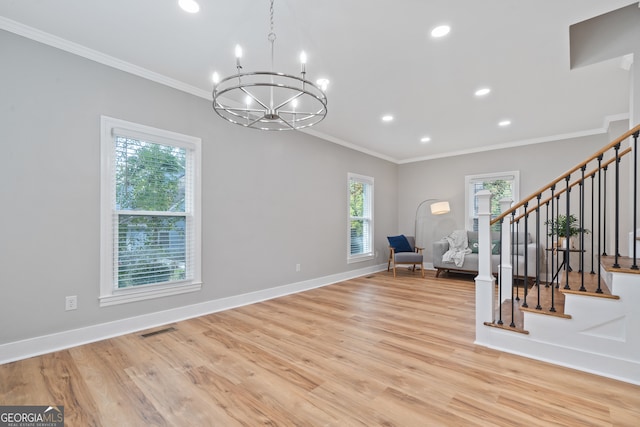 interior space with light hardwood / wood-style floors, an inviting chandelier, and ornamental molding