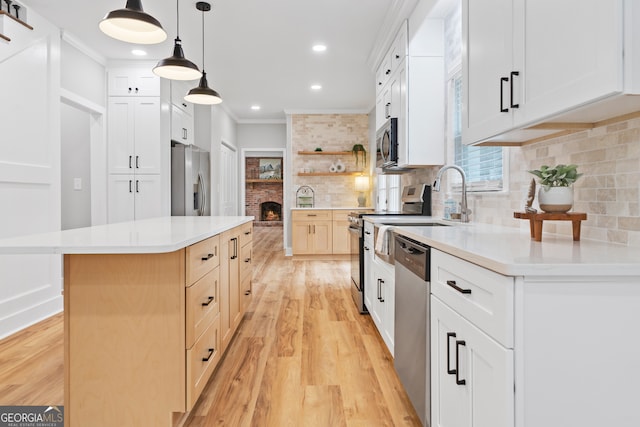 kitchen featuring a center island, decorative backsplash, decorative light fixtures, white cabinetry, and stainless steel appliances