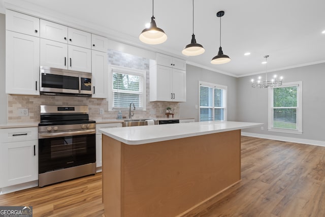 kitchen featuring white cabinets, a center island, light hardwood / wood-style floors, and appliances with stainless steel finishes