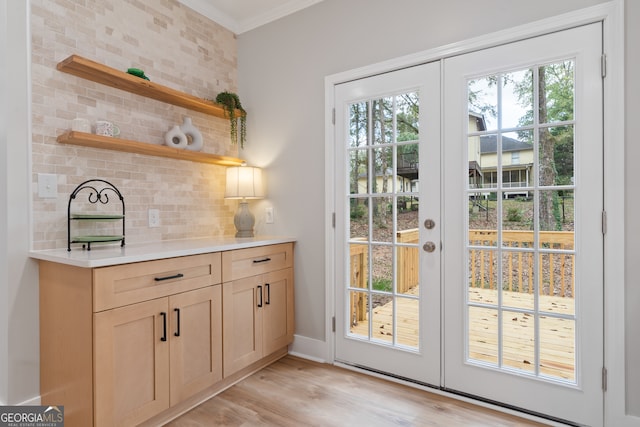 doorway to outside featuring french doors, light hardwood / wood-style flooring, and crown molding