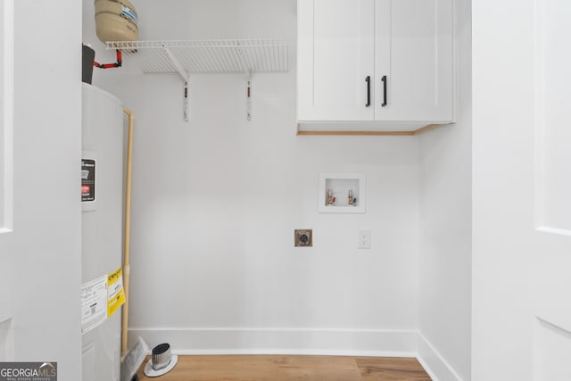 laundry room featuring electric dryer hookup, cabinets, electric water heater, hookup for a washing machine, and hardwood / wood-style flooring