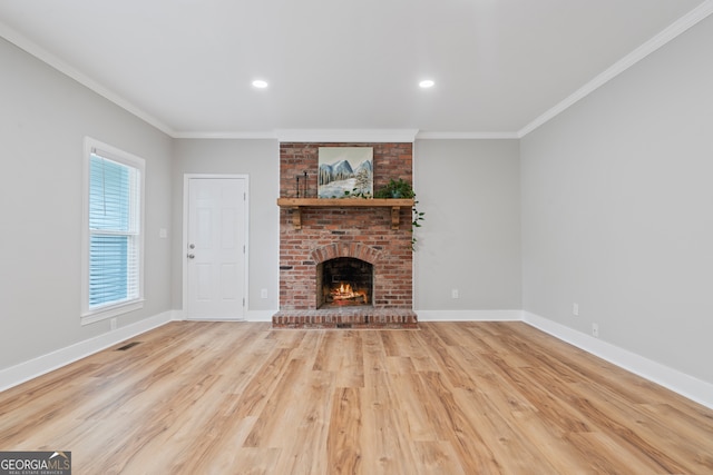 unfurnished living room featuring ornamental molding, a fireplace, and light hardwood / wood-style flooring