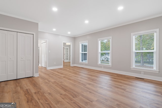 unfurnished bedroom featuring light wood-type flooring and ornamental molding