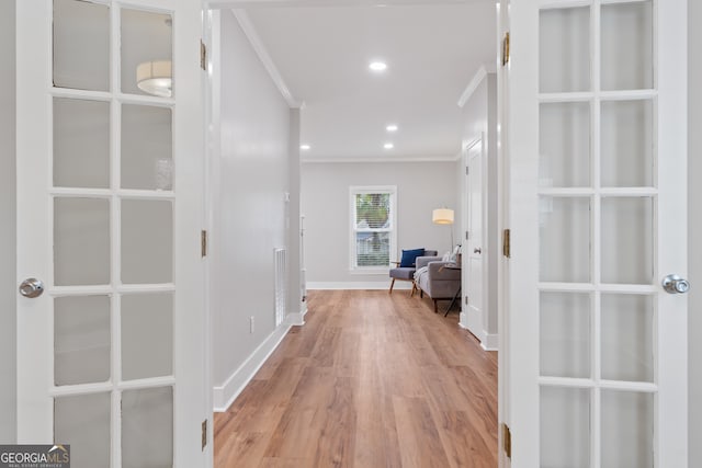 corridor with crown molding and light hardwood / wood-style flooring