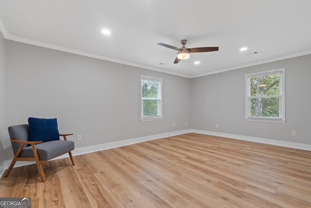 living area featuring ceiling fan, light wood-type flooring, and crown molding